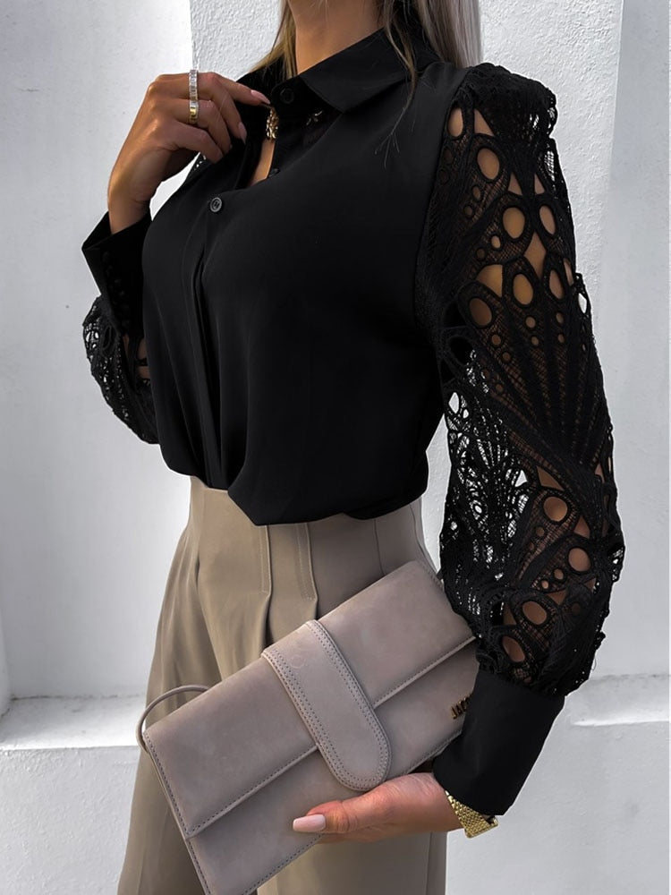Frau in schwarzer Bluse mit Spitzenärmeln, beige Hose, graue Clutch, elegante Mode.