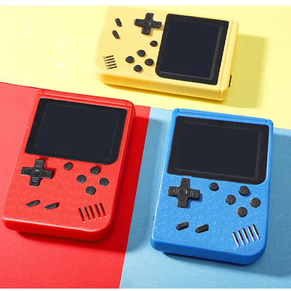 Drei tragbare Retro-Spielkonsolen in Rot, Gelb und Blau auf buntem Hintergrund.
