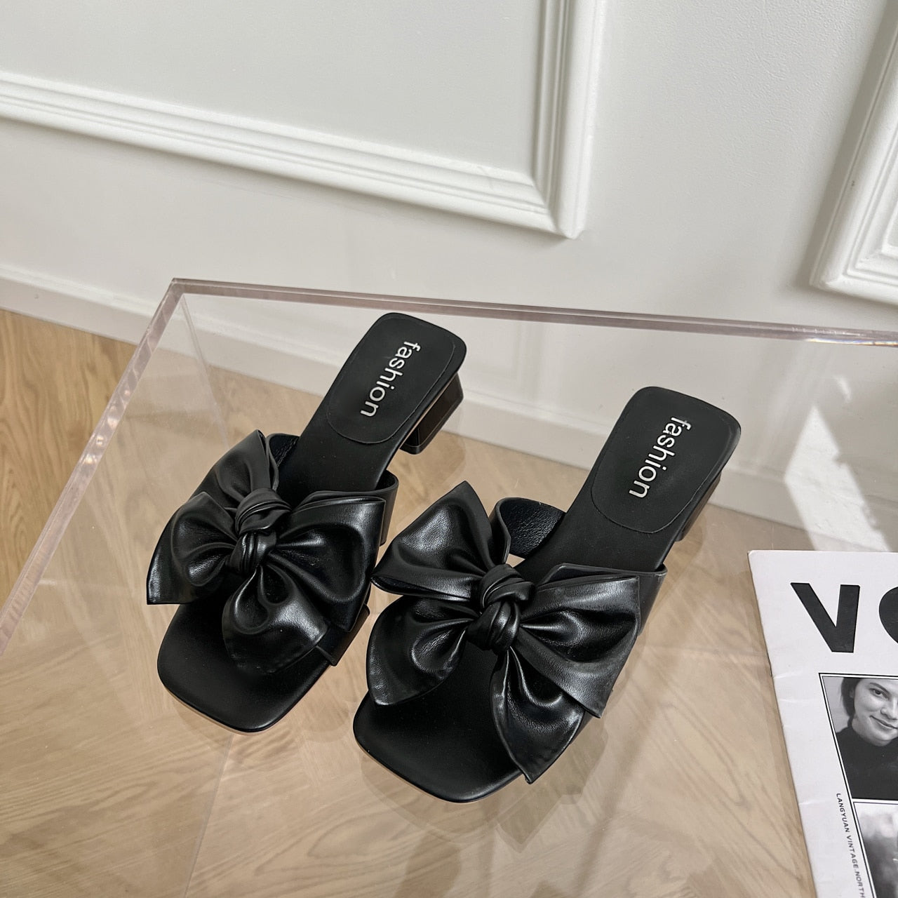 Schwarze Sandalen mit Schleife, Damenmode, elegantes Design, Sommerschuhe, modisch.