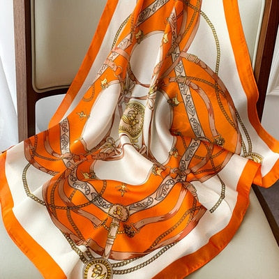 Orange-weißer Seidenschal mit Kettenmuster, luxuriöses Accessoire, modisch und elegant.