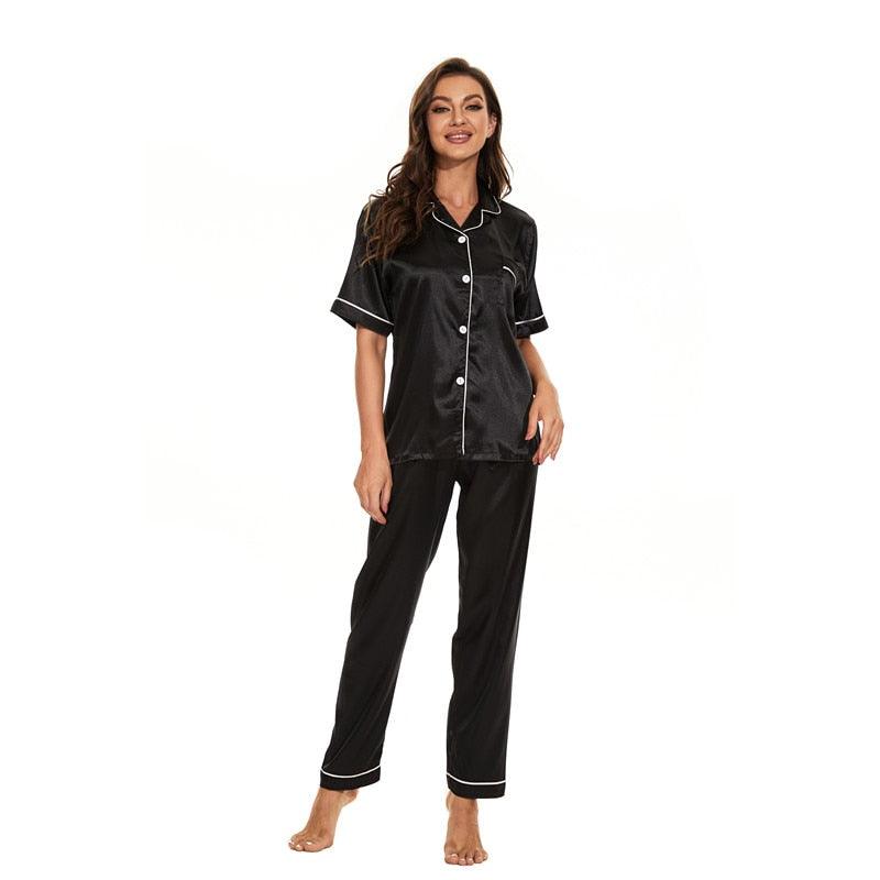Frau in schwarzem Satin-Pyjama-Set mit weißen Knöpfen und Paspeln, Nachtwäsche Damenmode.
