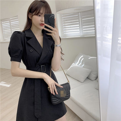 Frau in schwarzem Wickelkleid mit Handtasche, Selfie, modernes Wohnzimmer, Tageslicht.
