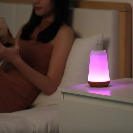 Lila LED-Nachtlicht auf Nachttisch, modernes Design, stimmungsvolle Beleuchtung, Schlafzimmer-Dekor.