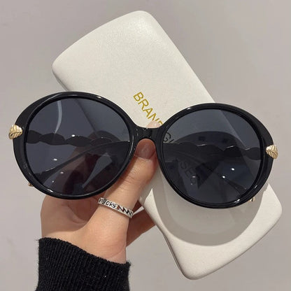 Schwarze runde Sonnenbrille mit Etui, Damenmode, UV-Schutz, stilvoll, elegant.