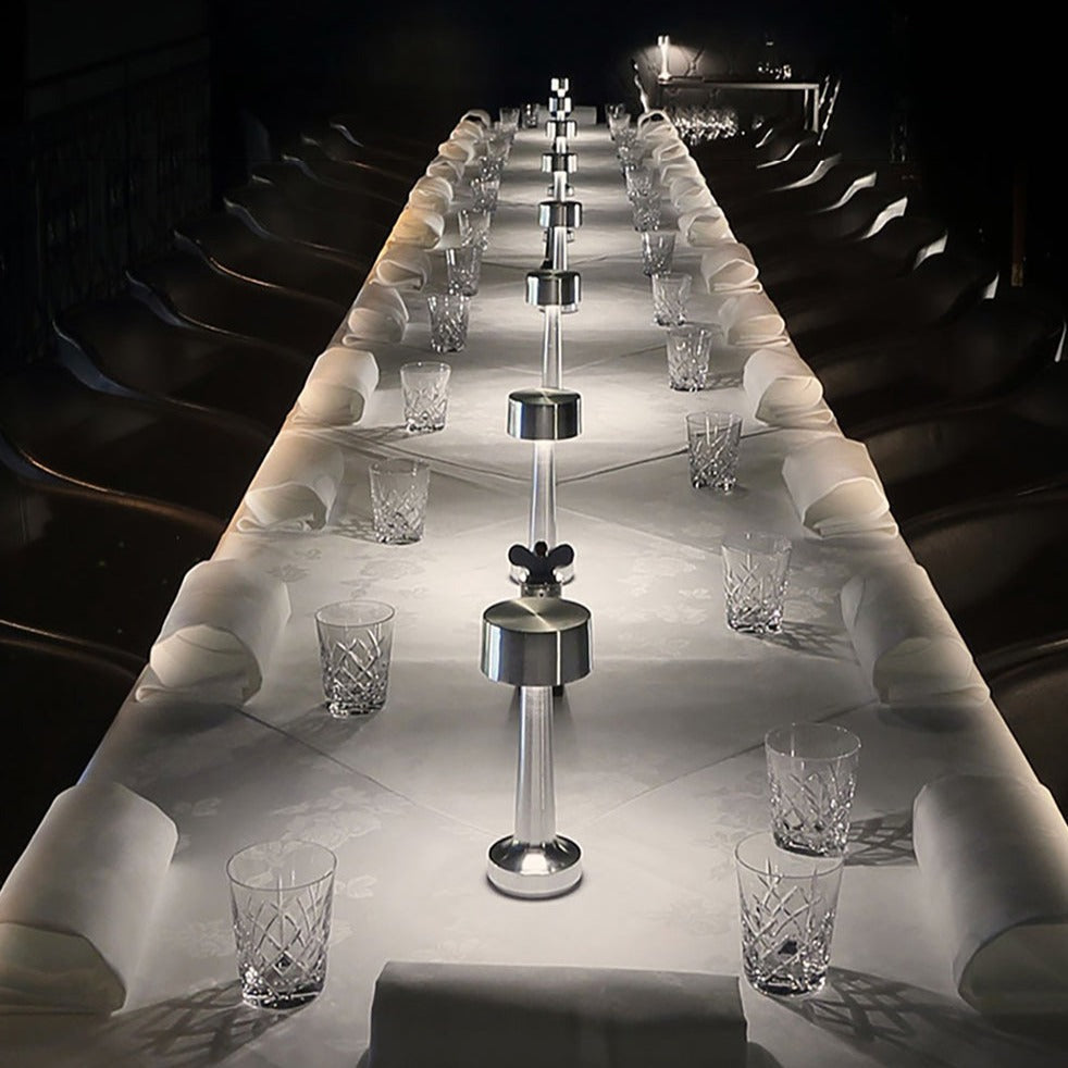 Langer, elegant gedeckter Tisch mit Kristallgläsern und silbernen Salz- und Pfefferstreuern.