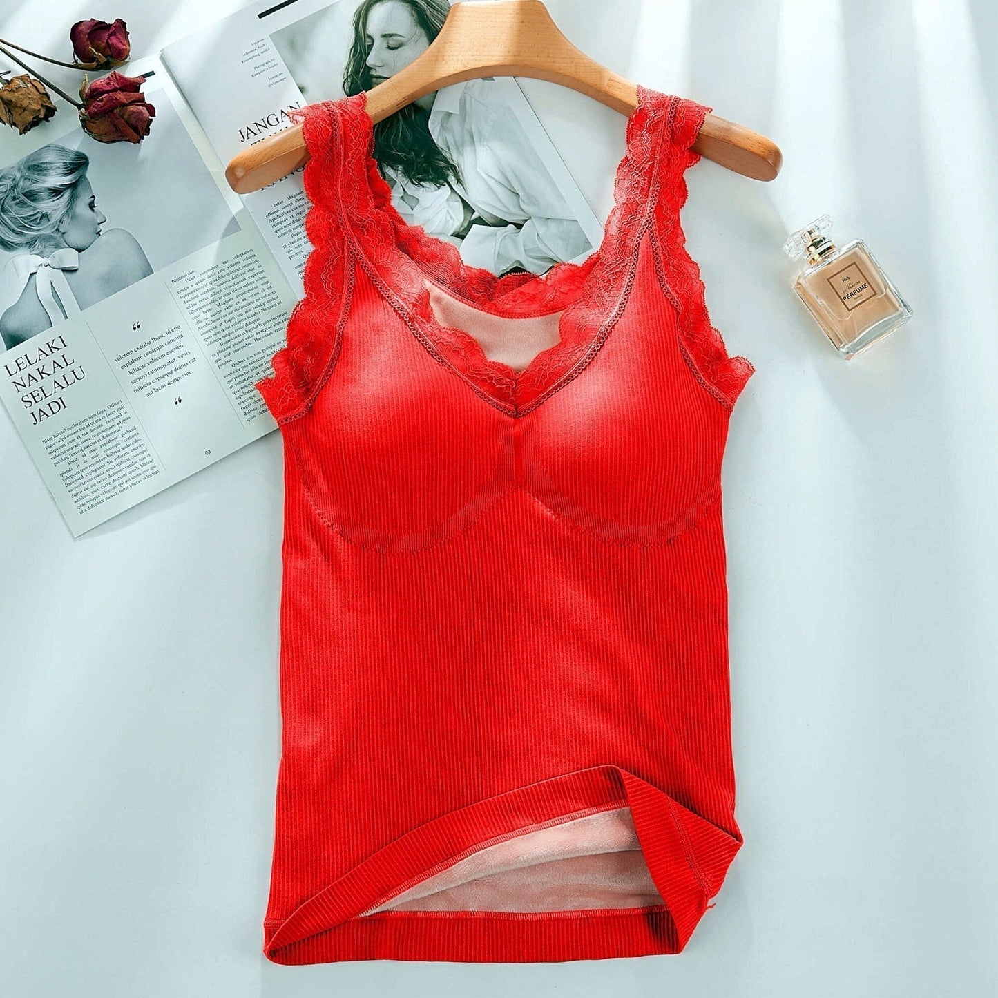 Rotes Damen-Spitzenunterhemd auf Holzkleiderbügel, geripptes Material, modisch, elegant.