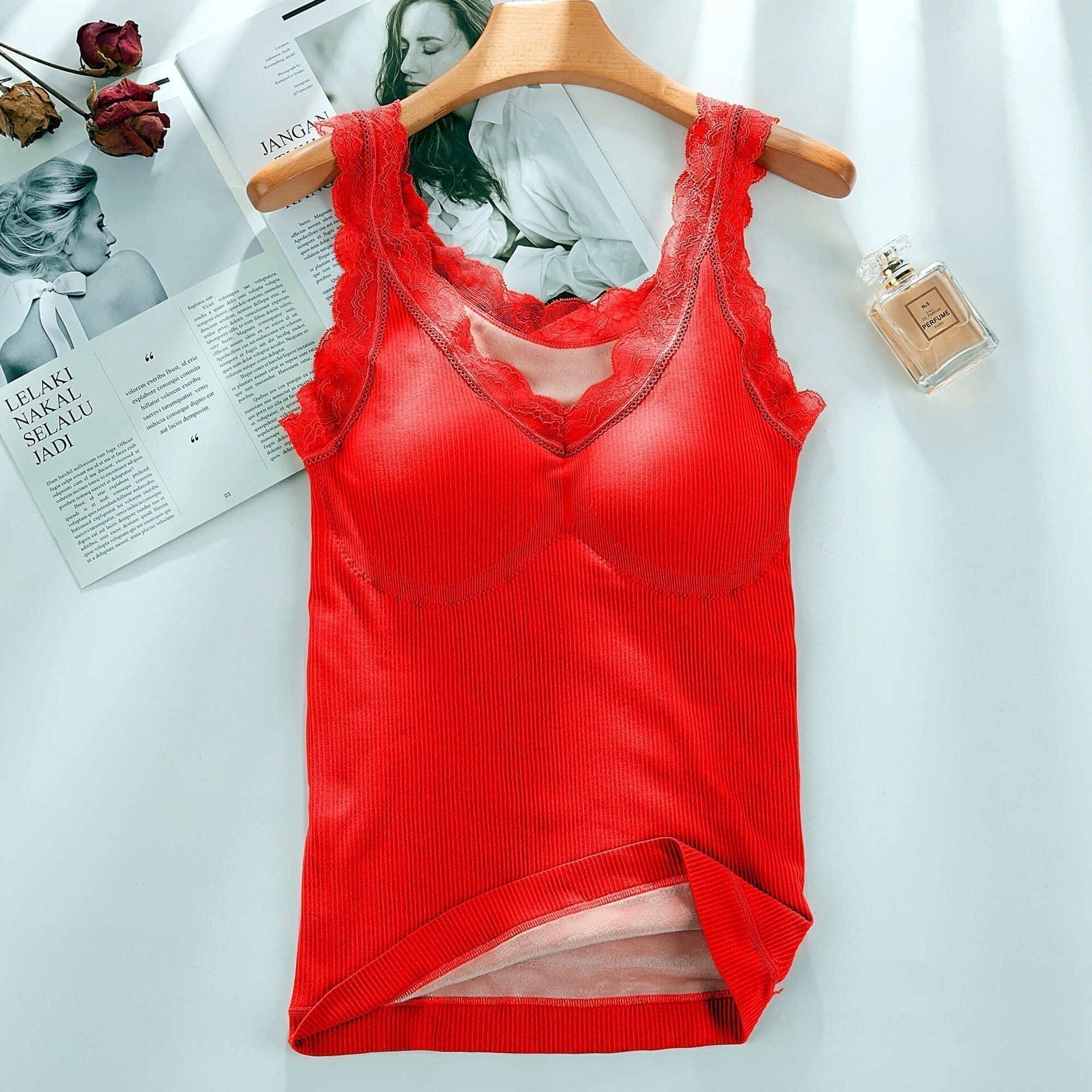 Rotes Damen-Spitzenunterhemd auf Holzkleiderbügel, geripptes Material, modisch, elegant.