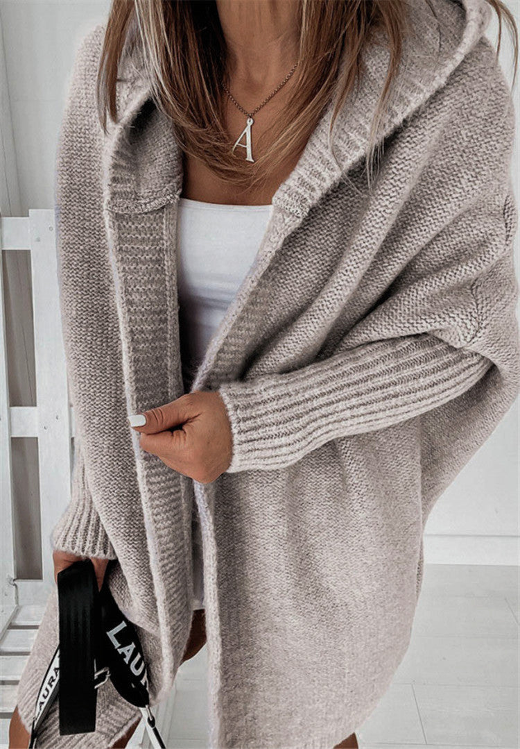 Frau in beigem Strickcardigan, weißem Top, mit Tasche, modisch, gemütlich, Herbstmode.