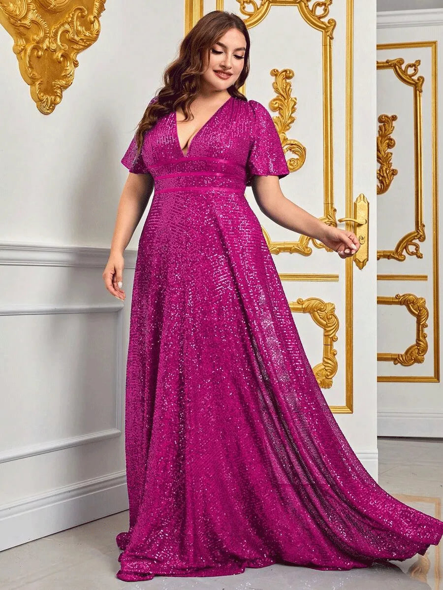 Frau in einem eleganten, pinken Paillettenkleid vor goldverzierter Wand.