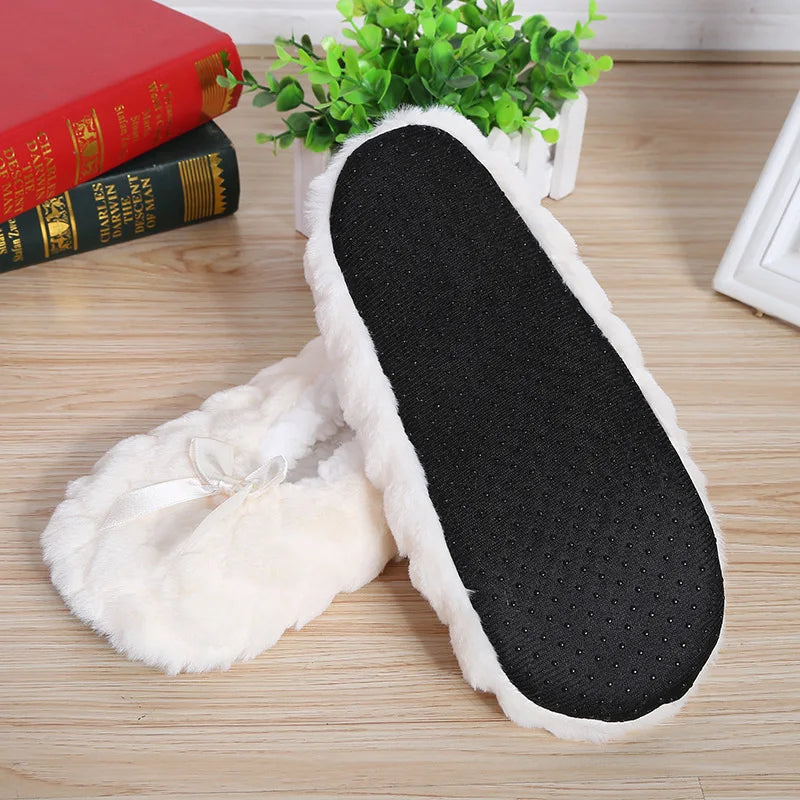 Weiße Plüsch-Hausschuhe mit schwarzer Sohle auf Holzboden, gemütlich und rutschfest.