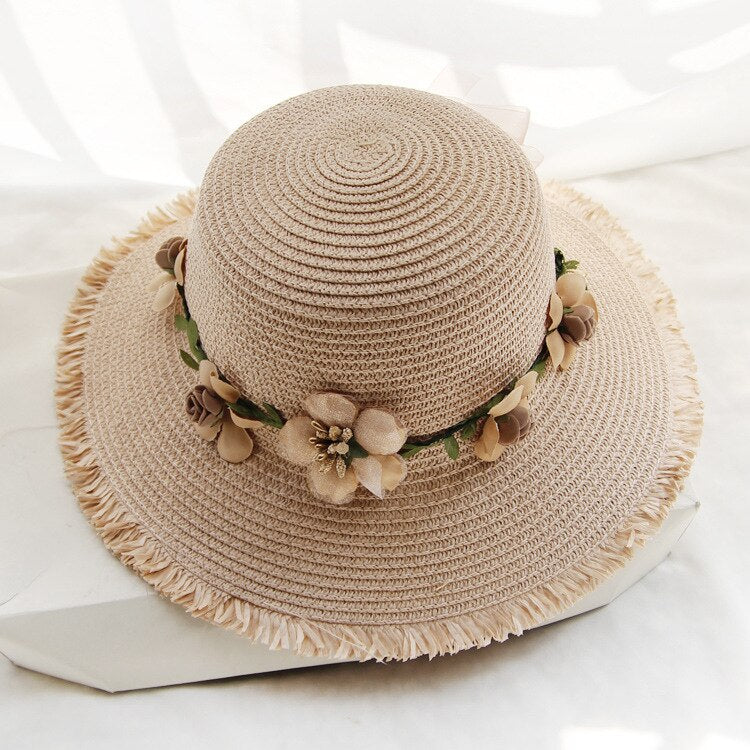 Beiger Damen-Sonnenhut aus Stroh mit Blumenverzierung, ideal für Sommermode und Strand.