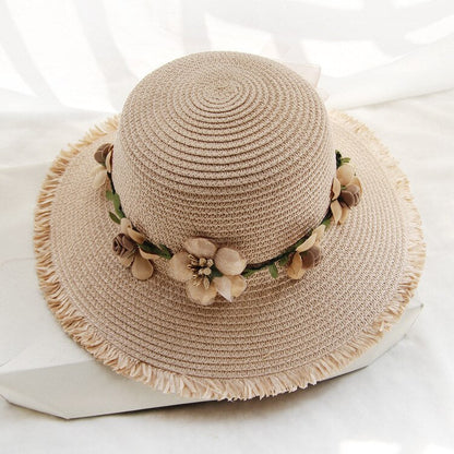 Beiger Damen-Sonnenhut aus Stroh mit Blumenverzierung, ideal für Sommermode und Strand.