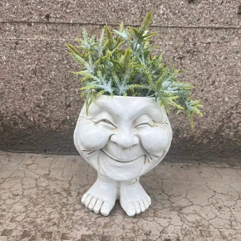 Weiße Keramik-Pflanzgefäß mit Gesicht, lächelnd, mit grüner Pflanze, dekorativ, Gartenaccessoire.
