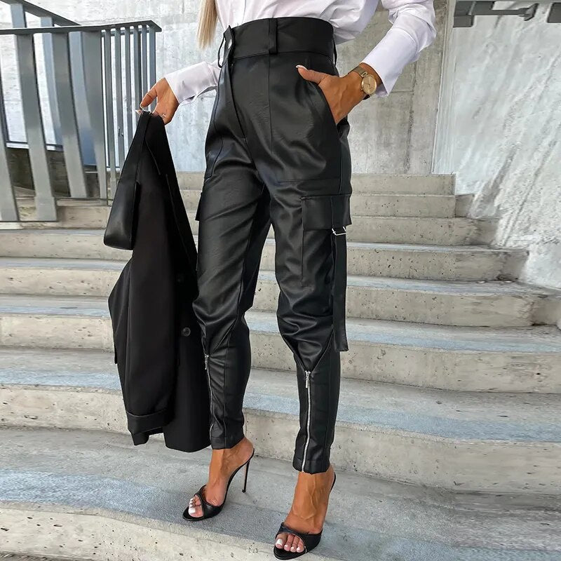 Frau in schwarzer Lederhose und High Heels auf Treppe, modisches Outfit, Business-Look.