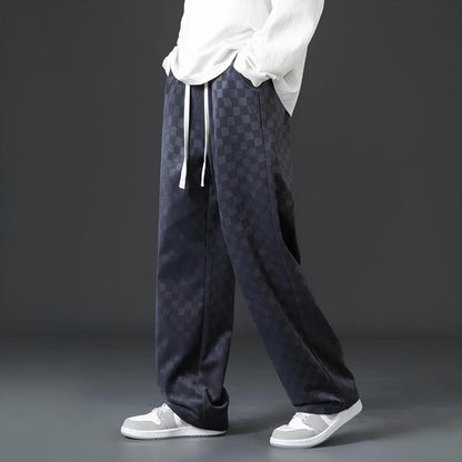 Dunkle karierte Hose, lässig, Herrenmode, Streetwear, mit weißen Sneakers und Hemd.