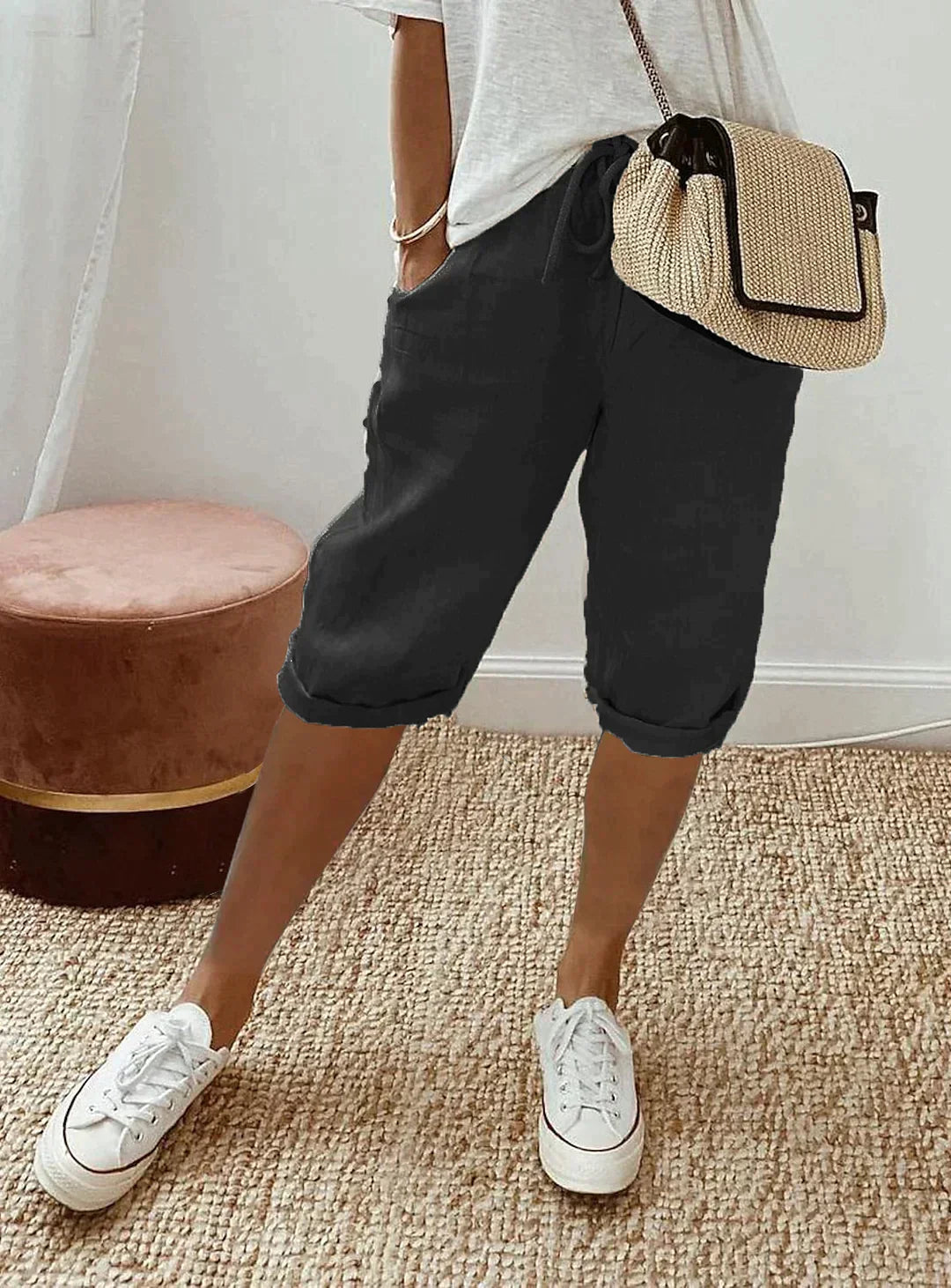 Damen Leinenhose schwarz, lässig, knielang, mit weißem T-Shirt und Sneakers, Sommermode.