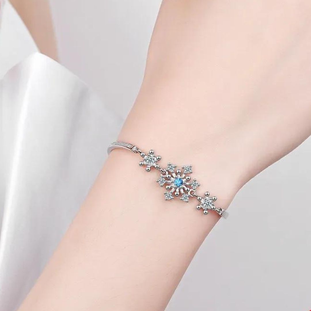 Silbernes Armband mit Schneeflocken-Design und blauen Kristallen, eleganter Schmuck.