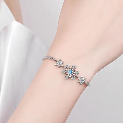 Silbernes Armband mit Schneeflocken-Design und blauen Kristallen, eleganter Schmuck.