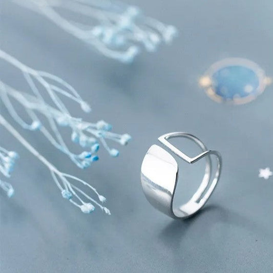 Silberring mit modernem Design auf blauem Hintergrund, minimalistisch, Schmuck für Damen.