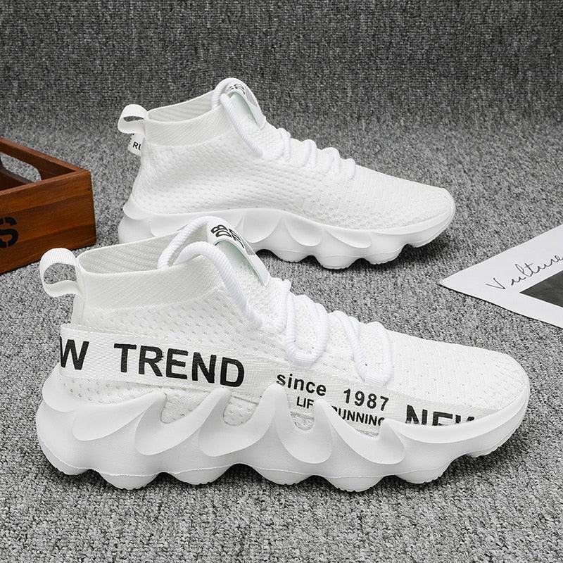 Weiße Sneaker mit welliger Sohle, atmungsaktivem Mesh, Aufschrift "NEW TREND", modisch.