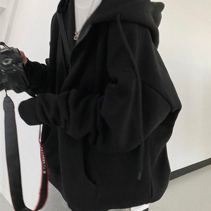 Person in schwarzem Hoodie mit Kamera, lässiger Stil, Fotografie, Mode, Freizeitkleidung.