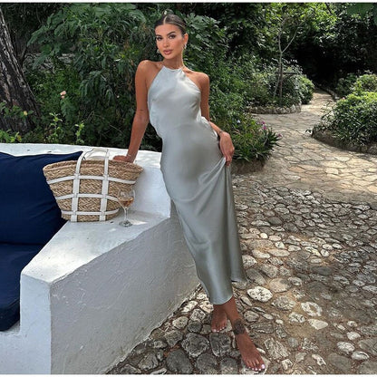 Frau in silbernem Satin-Kleid, Sommermode, Garten, elegantes Abendkleid, stilvoll, modern.