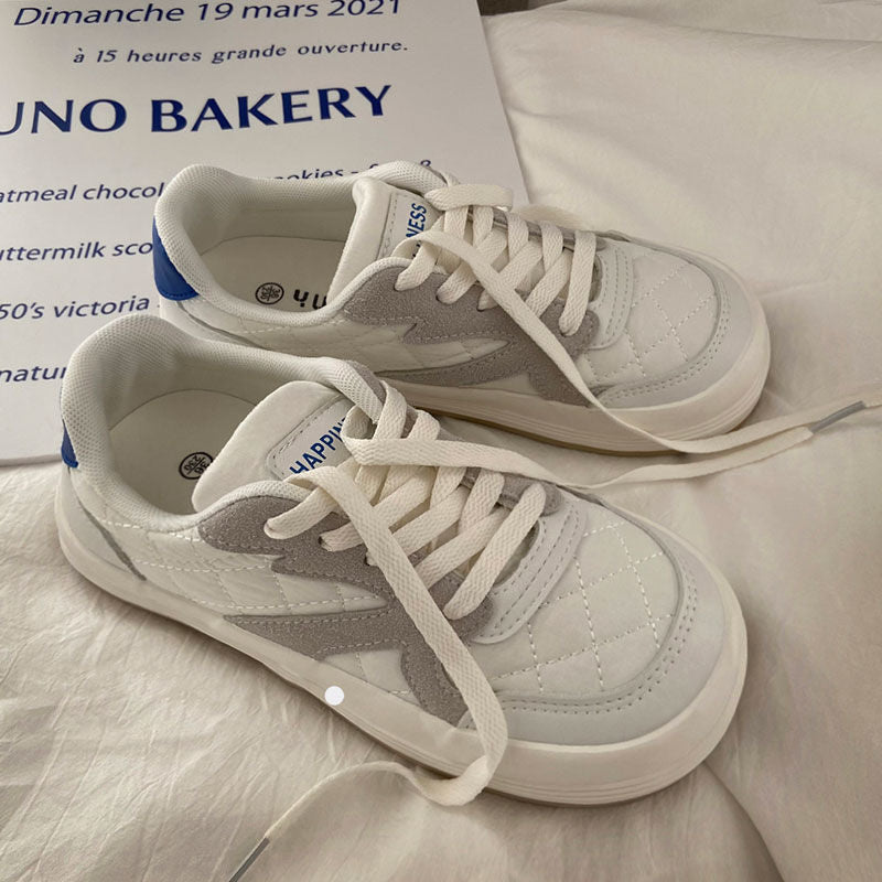 Weiße und graue Sneaker aus Leder mit blauen Akzenten auf weißem Hintergrund.