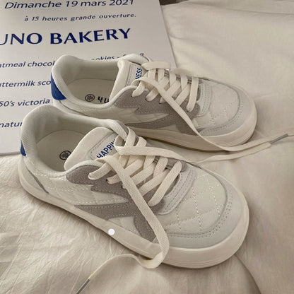 Weiße und graue Sneaker aus Leder mit blauen Akzenten auf weißem Hintergrund.