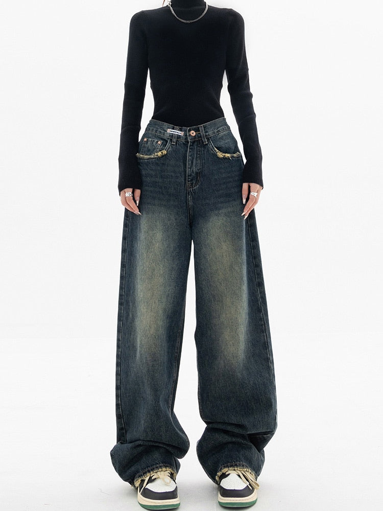 Frau in schwarzem Pullover und weiten Jeans, Streetwear-Mode, lässiger Stil.