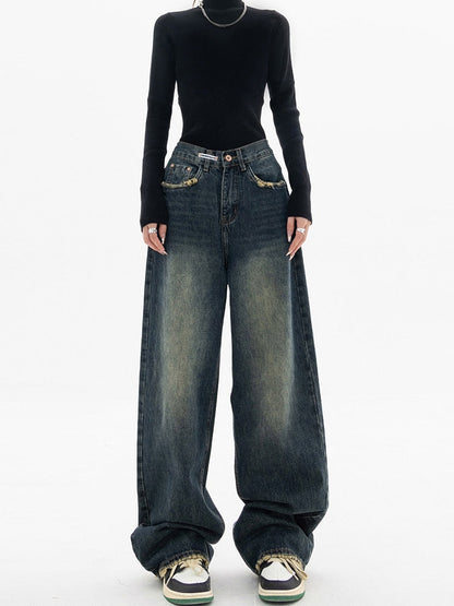 Frau in schwarzem Pullover und weiten Jeans, modische Streetwear, lässiger Stil.
