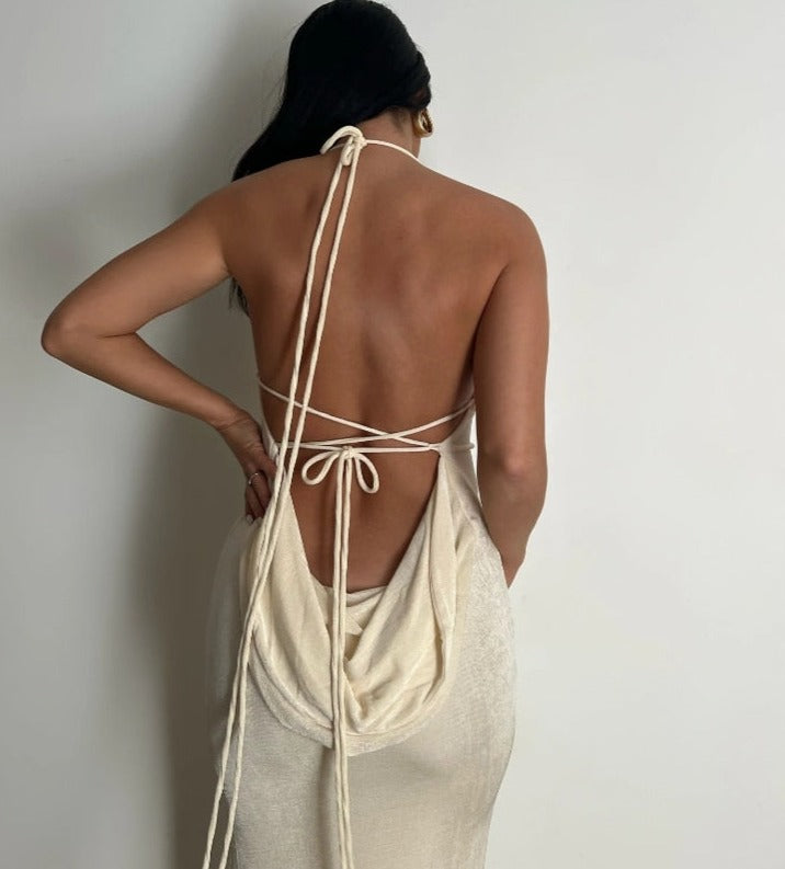 Frau in cremefarbenem Rückenfreies Kleid mit Schnürung, elegantes Sommeroutfit.