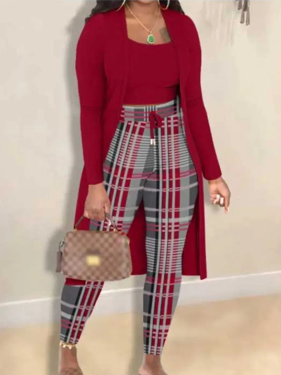 Frau in rotem Cardigan und karierten Leggings, hält eine braune Handtasche.