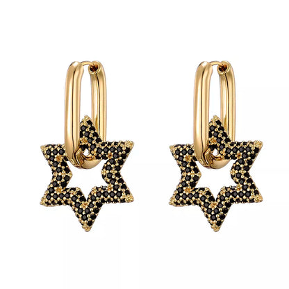 Goldene Ohrringe mit schwarzen Sternanhängern, eleganter Schmuck, modisches Accessoire.