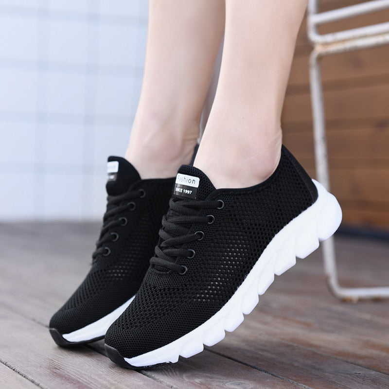 Schwarze Damen-Sneaker aus Mesh mit weißer Sohle, atmungsaktiv, modisch, bequem.