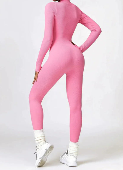 Frau in rosa nahtlosem Jumpsuit, sportlich, figurbetont, mit weißen Sneakers und Socken.