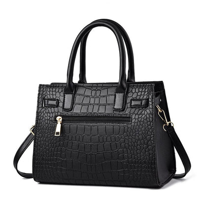 Schwarze Damenhandtasche aus Kunstleder mit Krokodilprägung und abnehmbarem Schulterriemen.