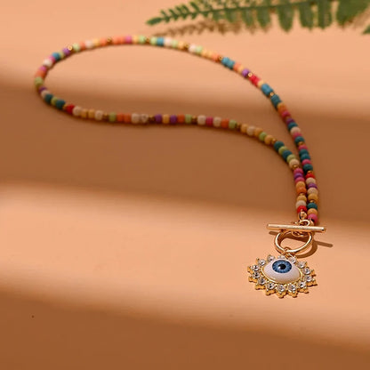 Bunte Perlenkette mit Auge-Anhänger, modisches Schmuckstück, Damenaccessoire, Boho-Stil.