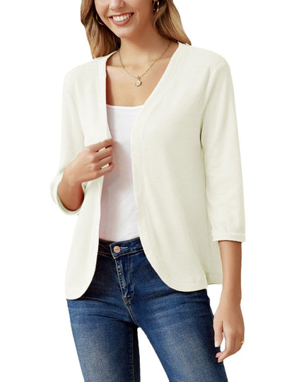 Frau trägt weiße Strickjacke, V-Ausschnitt, 3/4-Ärmel, lässig, Damenmode, Freizeitlook.