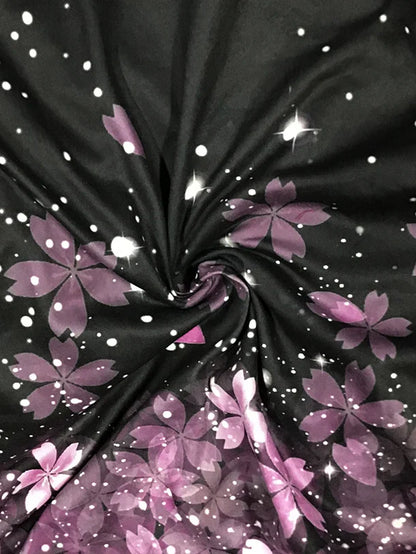 Schwarzer Stoff mit lila Blumenmuster, glänzend, für Bekleidung und Dekoration.