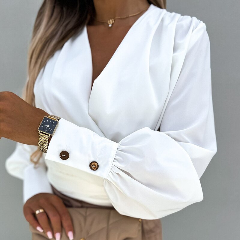 Frau in weißer Bluse mit Ballonärmeln und goldener Uhr, elegantes Outfit, Modeaccessoires.