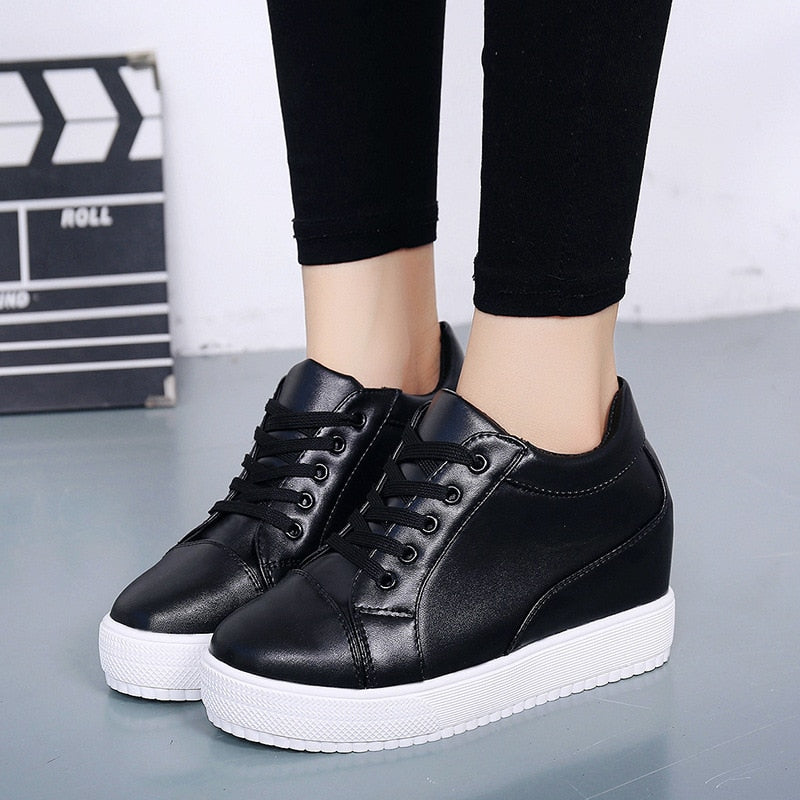 Schwarze Damen-Sneaker mit Keilabsatz, Lederoptik, weiße Sohle, modisch, bequem.