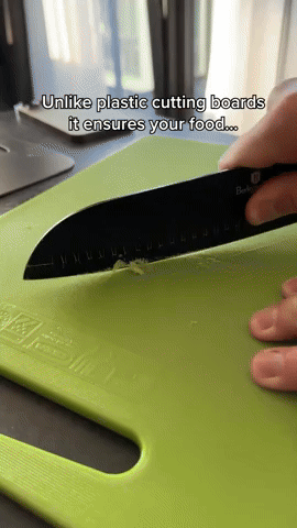 Kniv skär i mat på en grön plastskärbräda för jämförelse med metallbrädan, bildruta från en video. 6