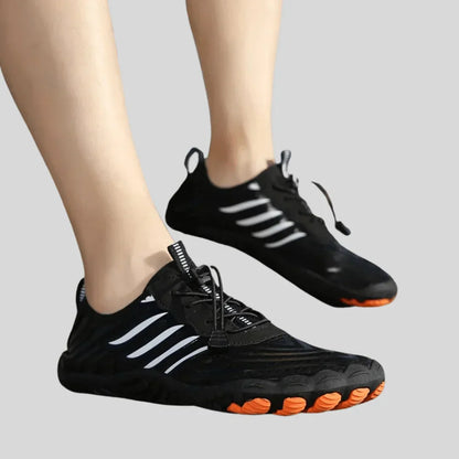 Schwarze Sportschuhe mit weißen Streifen und orangefarbener Sohle, ideal für Fitness und Laufen.