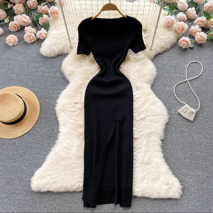 Schwarzes Abendkleid mit Schlitz, elegant, figurbetont, auf weißem Fell, umgeben von Rosen.