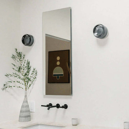 Moderner Badezimmer-Wandspiegel mit schwarzem Wasserhahn und dekorativer Vase auf weißem Waschtisch.