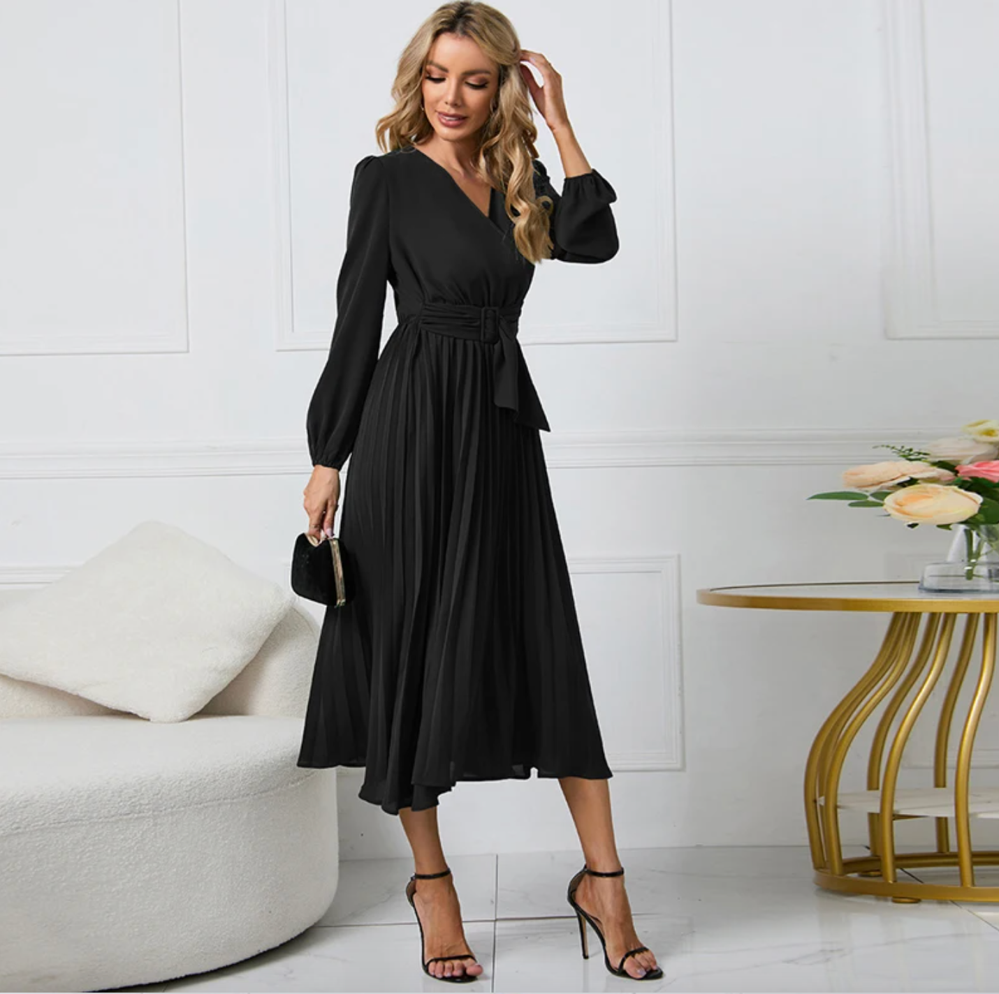 Frau in elegantem schwarzen Kleid, Plissee, V-Ausschnitt, Abendmode, stehend im Wohnzimmer.