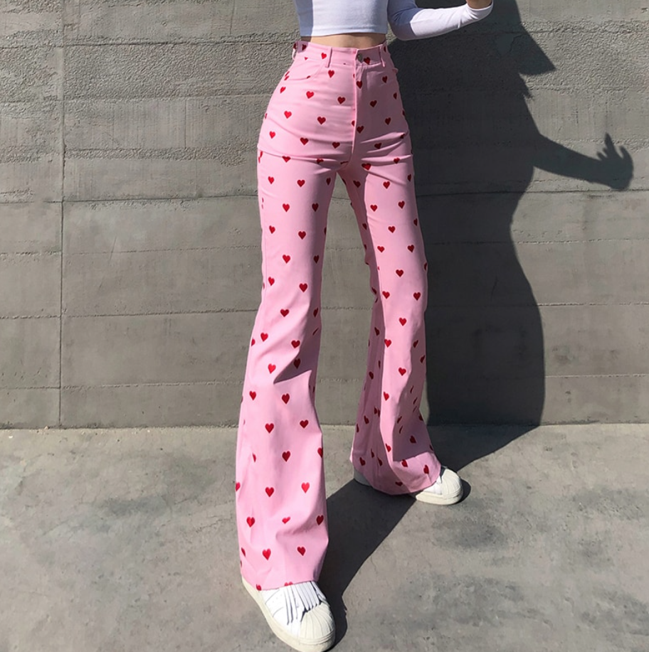 Frau in rosa Schlaghose mit roten Herzen, modisch, trendig, Streetwear, Damenmode.