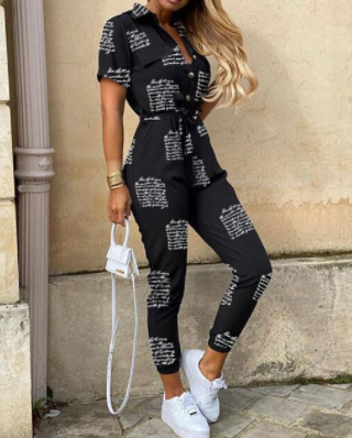 Schwarzer Damen-Jumpsuit mit weißem Schriftmuster, kurze Ärmel, Bindegürtel, modisch.