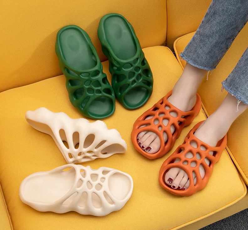 Damen Sandalen, orange und grün, atmungsaktiv, rutschfest, bequem, auf gelbem Sofa.
