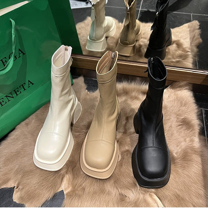 Drei Paar Stiefeletten in Weiß, Beige und Schwarz auf Fell, modisch, Damenstiefel, Leder.